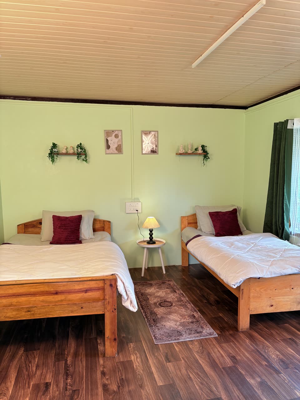 Sage-green bedroom of Cottage One with white linen