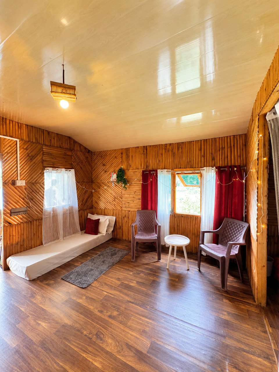 The lounge of Cottage Two — bamboo walls, a daybed and fairy lights